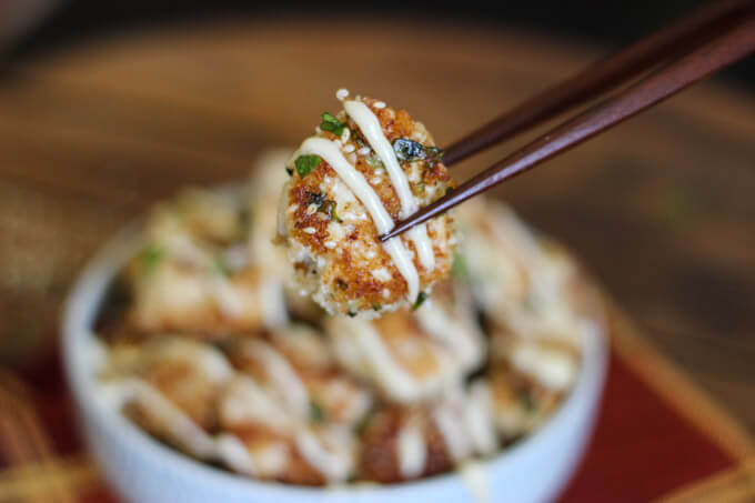 chopstick holding piece of crispy chicken.