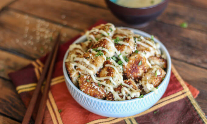 chicken bites inside a bowl with a side of chopsticks on the side.