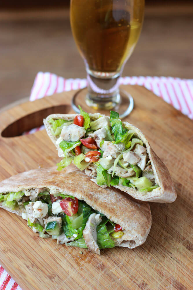 Greek chicken pita with a side of drink on the side.