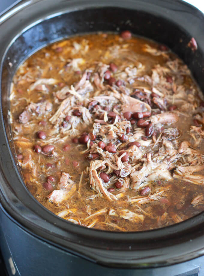 shredded pork and beans inside a crockpot.