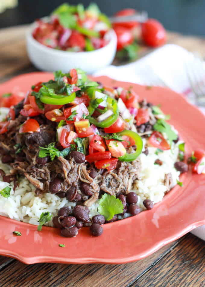 close up sideview of slow cooker pork and beans on a plate.