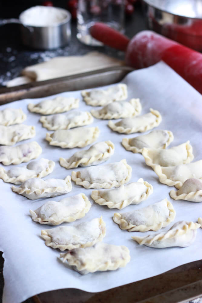 assembled vareniki on baking sheet.