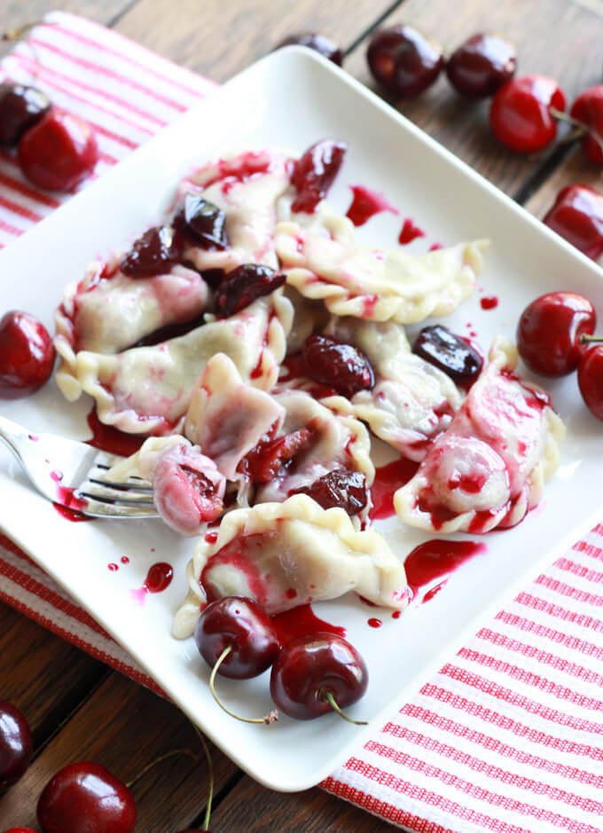 cherry vareniki on a white plate.