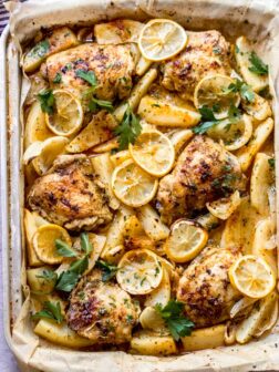 close up roasted chicken and potatoes in a baking pan