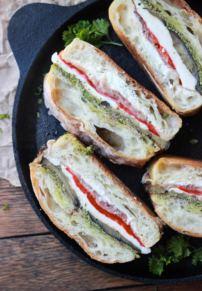 cut up italian prosciutto sandwich on a black plate. 