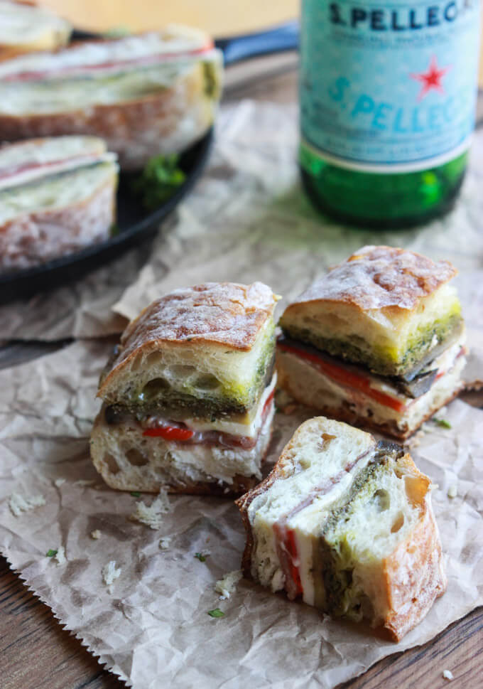 ciabatta sandwich with vegetables with a side of mineral water.