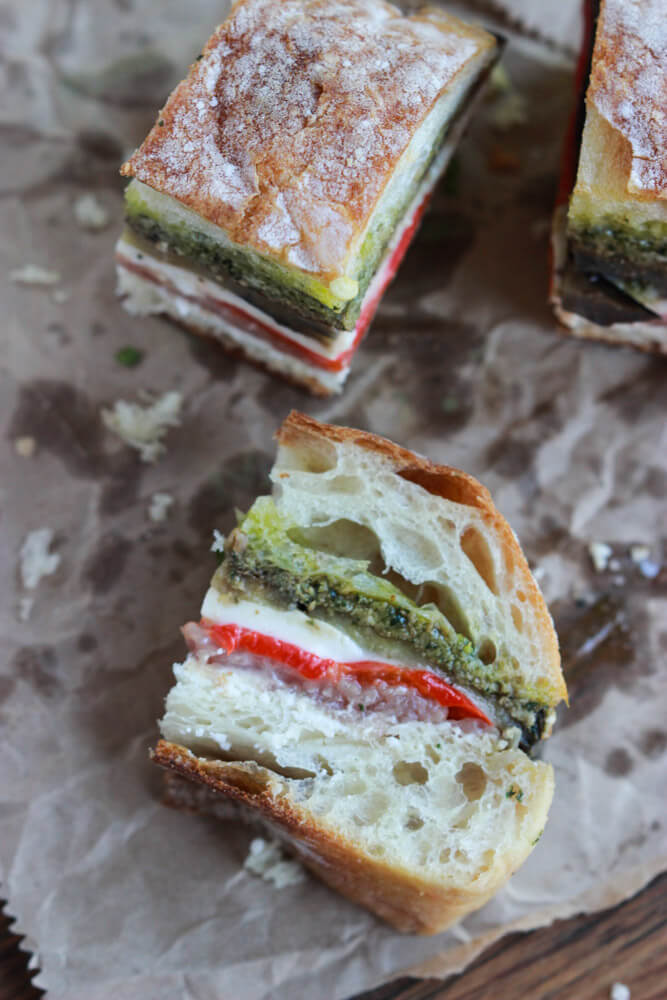 cut up sandwich laying on a side on parchment paper.