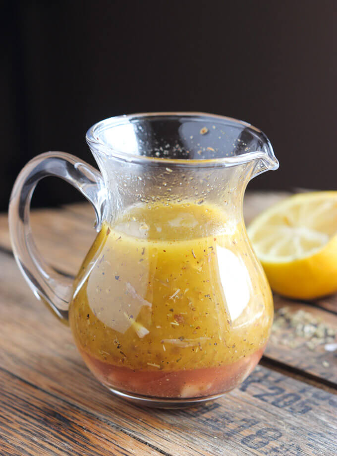 Greek salad dressing in glass container.