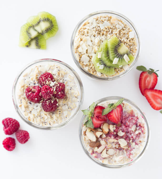 overnight oats in glass jars with fresh fruit on top.