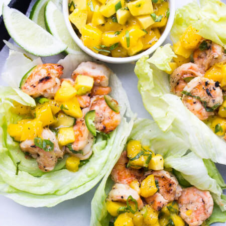 Quick and easy dinner or appetizer - spicy coconut milk marinated shrimp, grilled, and topped with fresh mango salsa | littlebroken.com @littlebroken