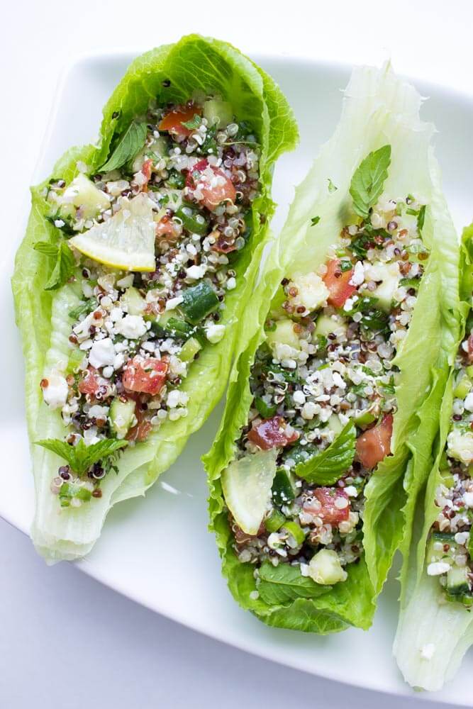 Quinoa with cucumbers, tomatoes, fresh herbs, and feta stuffed into crispy romaine leaf. Easy, healthy and meatless | littlebroken.com @littlebroken 