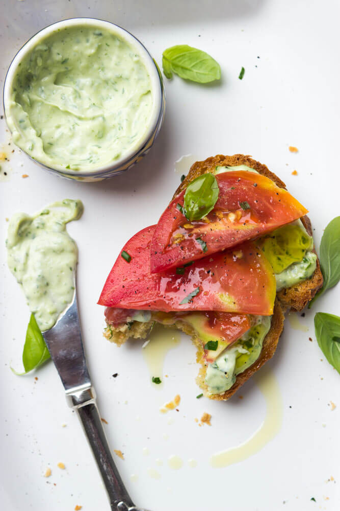 Crisp toast topped with garlic-herb mayonnaise and sweet juicy heirloom tomato slices. Breakfast, lunch, or dinner at its finest | littlebroken.com @littlebroken