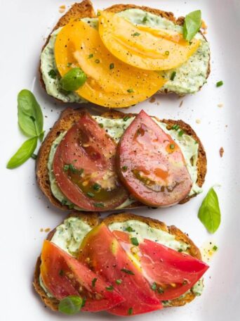 Crisp toast topped with garlic-herb mayonnaise and sweet juicy heirloom tomato slices. Breakfast, lunch, or dinner at its finest | littlebroken.com @littlebroken