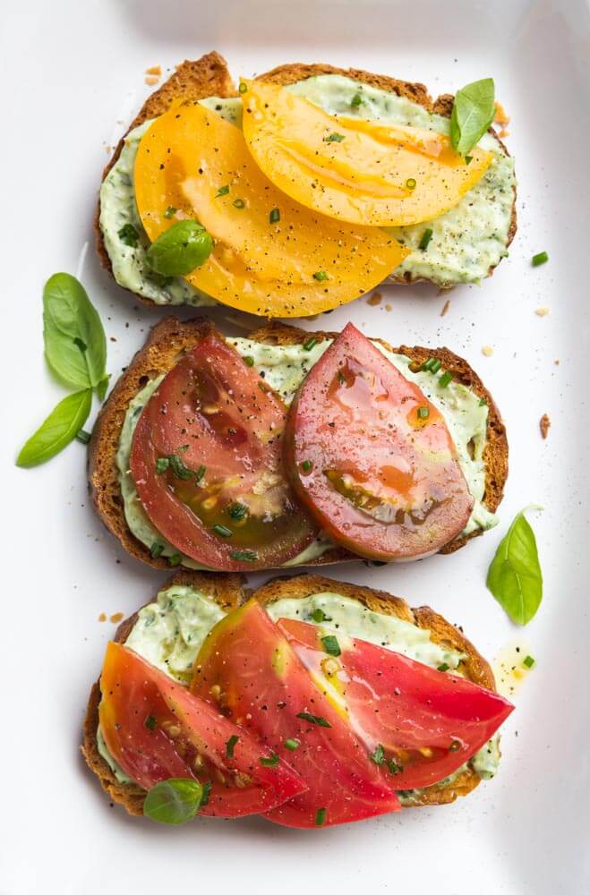 Crisp toast topped with garlic-herb mayonnaise and sweet juicy heirloom tomato slices. Breakfast, lunch, or dinner at its finest | littlebroken.com @littlebroken