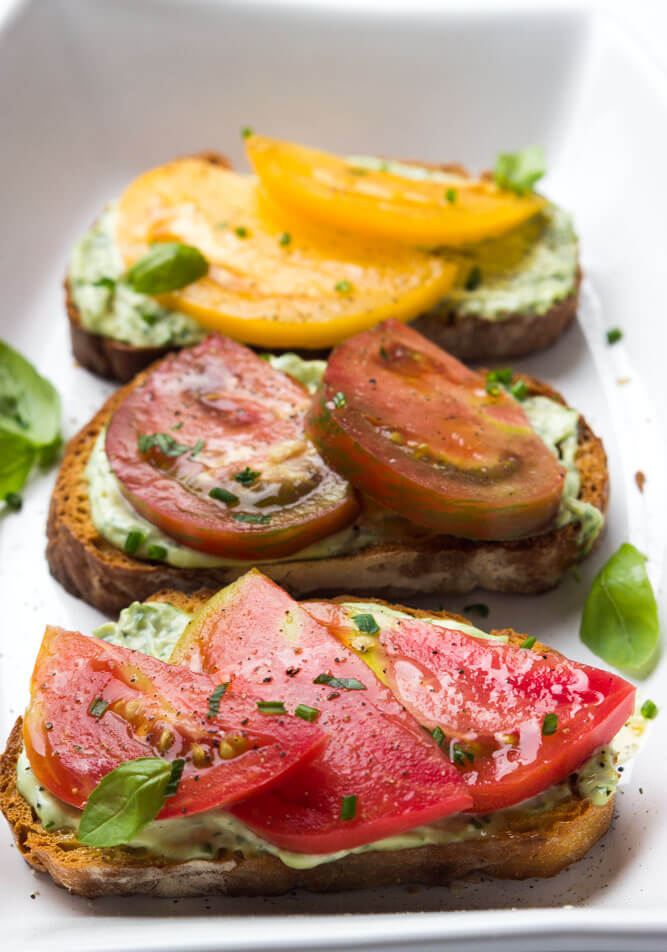 Crisp toast topped with garlic-herb mayonnaise and sweet juicy heirloom tomato slices. Breakfast, lunch, or dinner at its finest | littlebroken.com @littlebroken