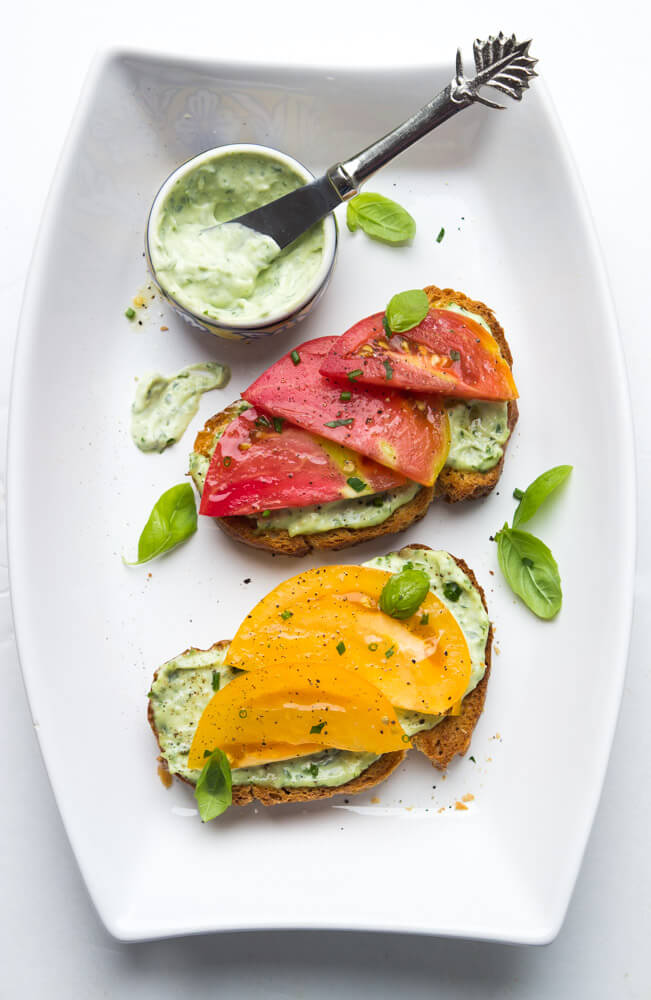 Crisp toast topped with garlic-herb mayonnaise and sweet juicy heirloom tomato slices. Breakfast, lunch, or dinner at its finest | littlebroken.com @littlebroken