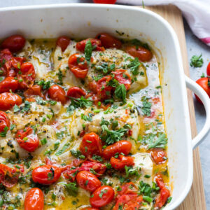 Close up side view of cod in tomato herb butter