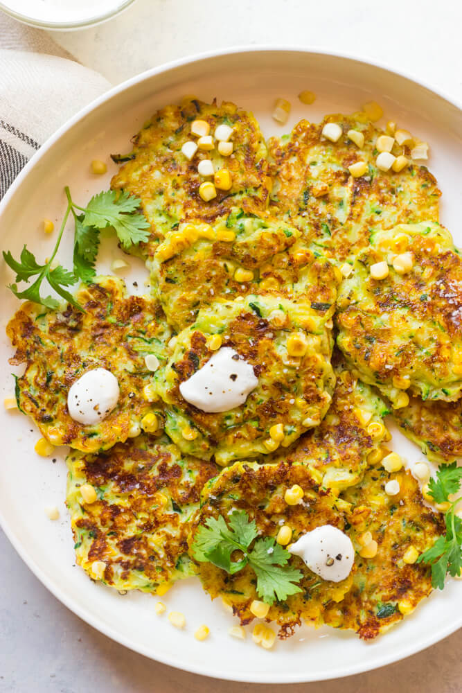 Close up view of zucchini corn fritters  recipe on white platter