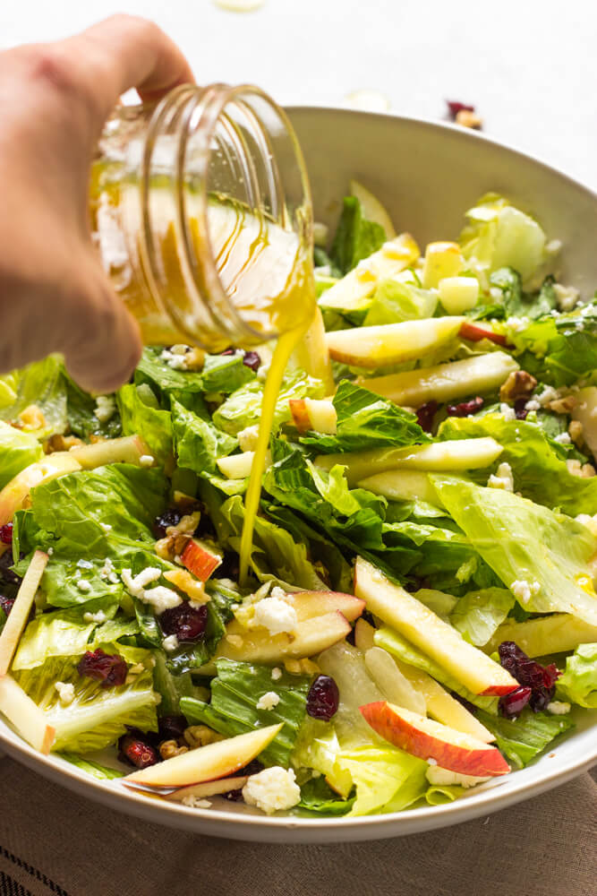 apple salad with romaine in a bowl with dressing.