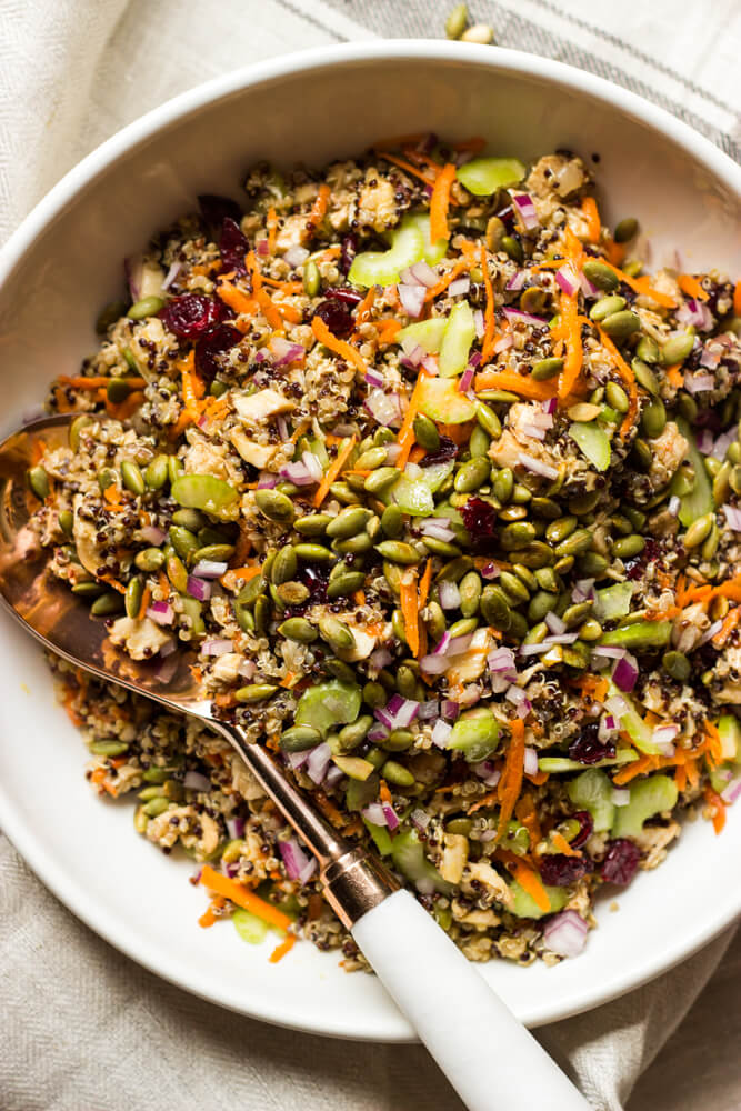 quinoa salad recipe with sunflower seeds in a bowl with a side of spoon.