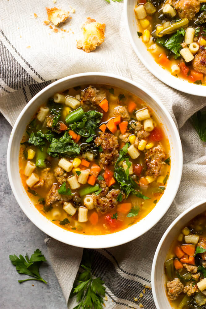 close up sausage and kale soup in white bowl