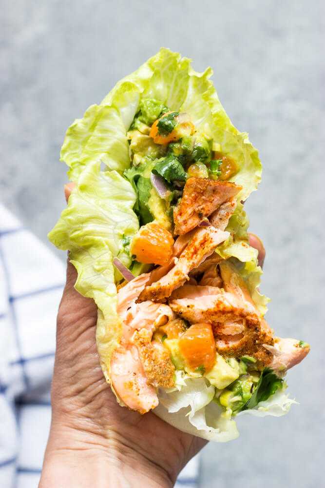 flakes salmon with orange salsa inside lettuce leaf.