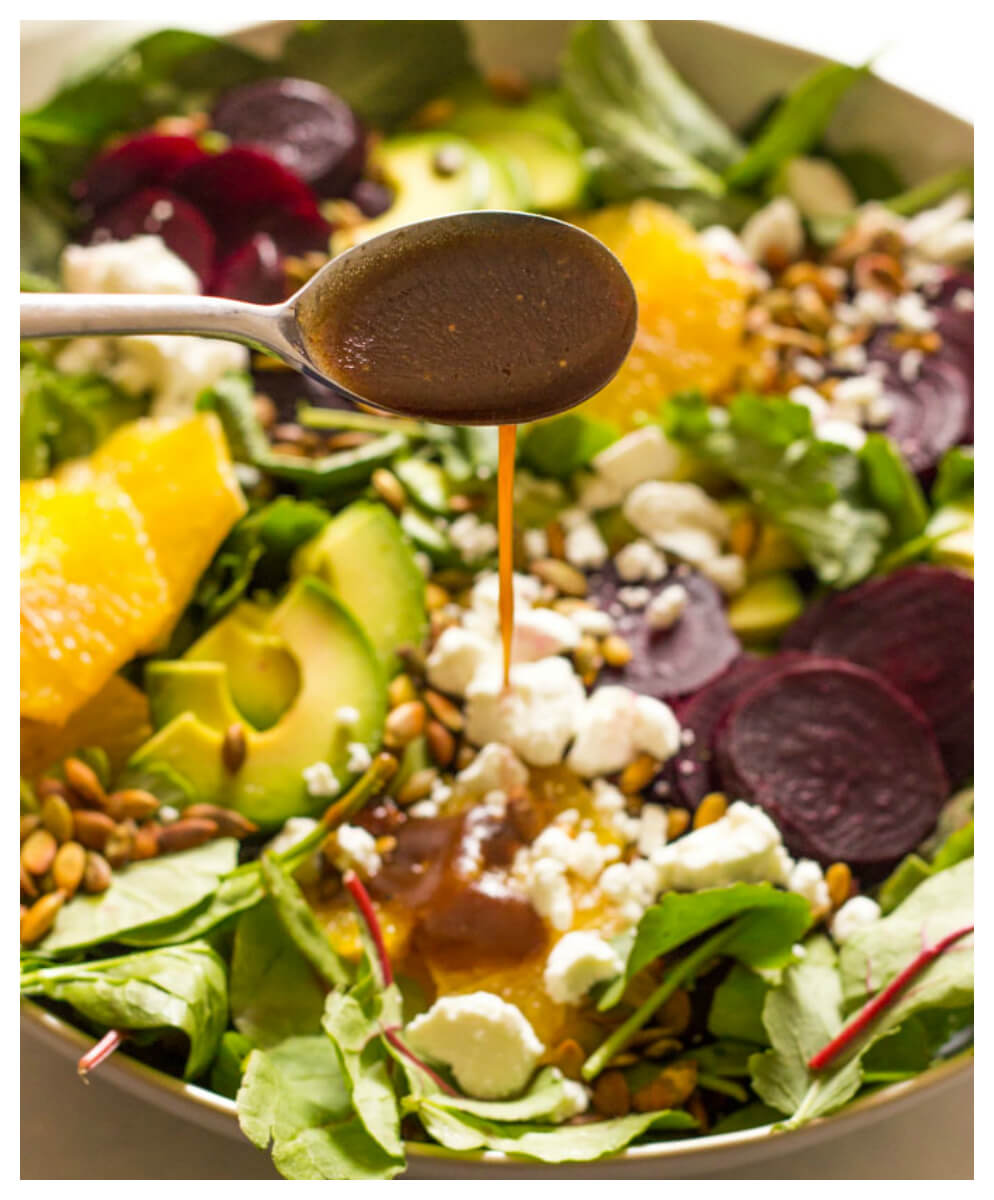 Close up of beet salad dressing poured over roasted beet salad