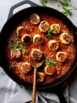 Healthy chicken meatballs in marinara sauce in black cast-iron skillet