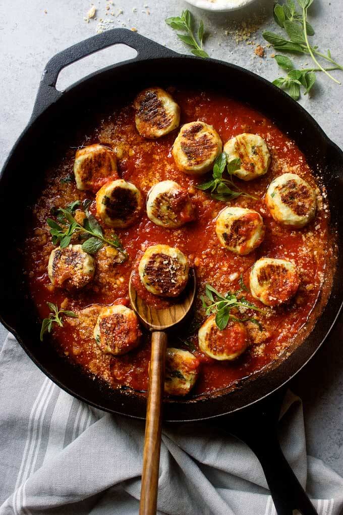 Healthy chicken meatballs in marinara sauce in black cast-iron skillet