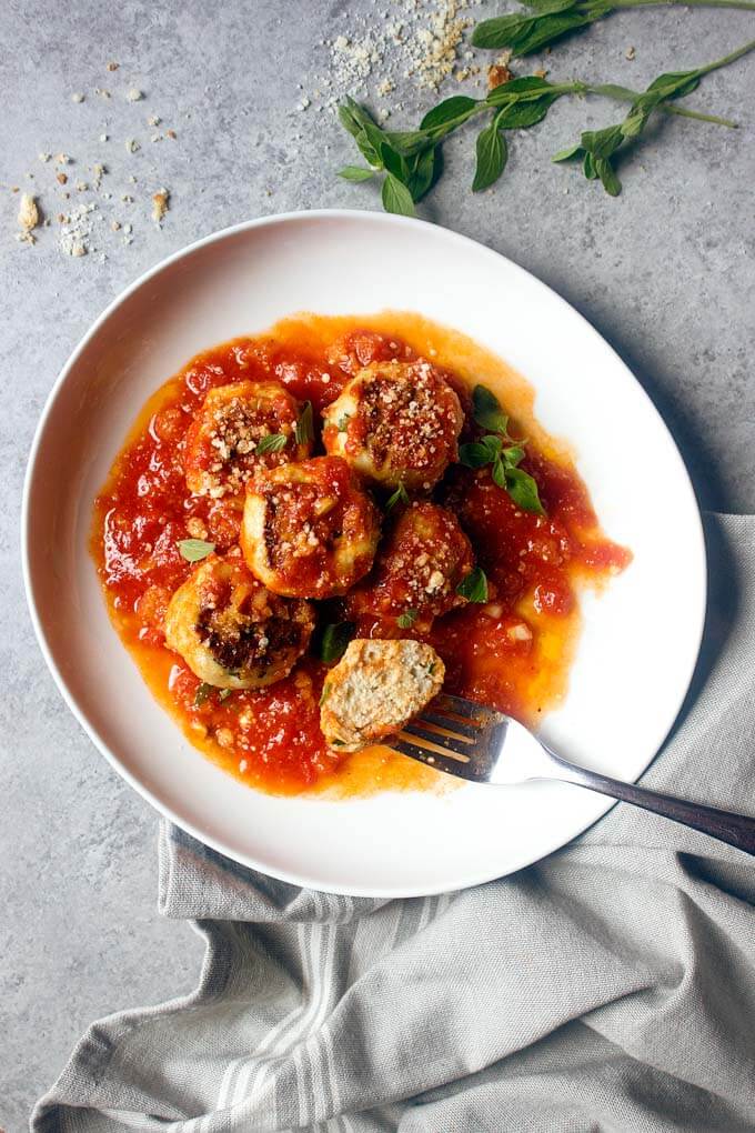 Healthy chicken meatballs on white plate with fork on side