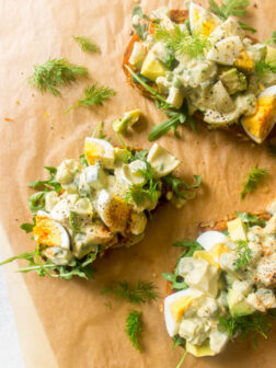 Close up of avocado egg salad on toast with arugula.