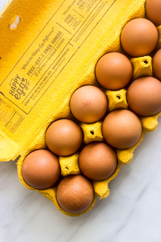 Overhead brown eggs in yellow egg carton