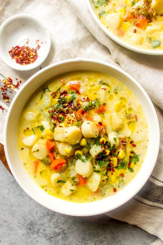 Close up of chowder recipe with scallops in white bowl