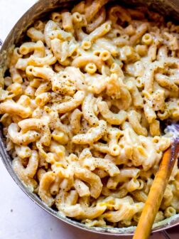 Overhead one pot mac and cheese in dutch-oven with wooden spoon