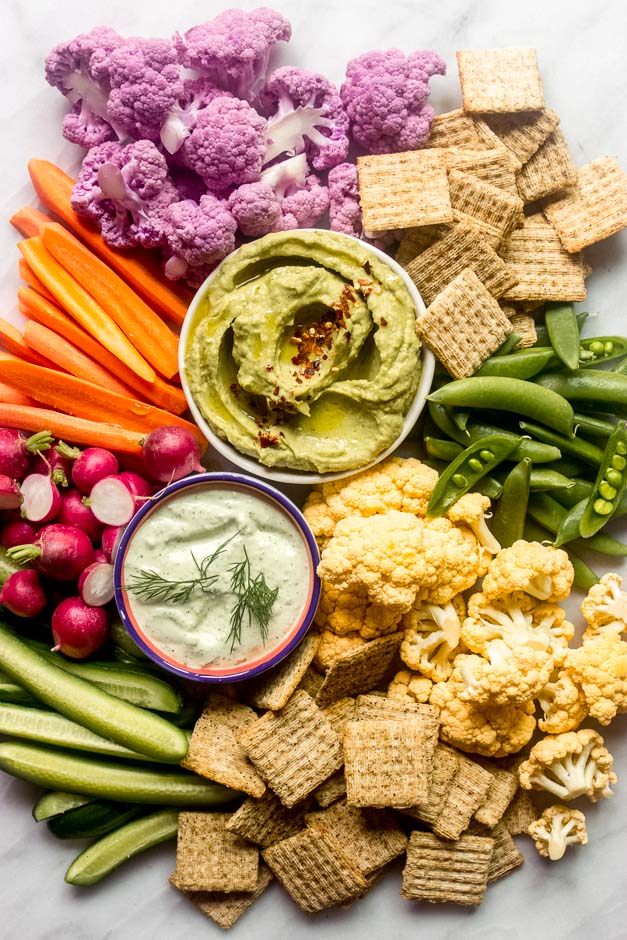 Overhead crudite platter with vegetable dips in the middle