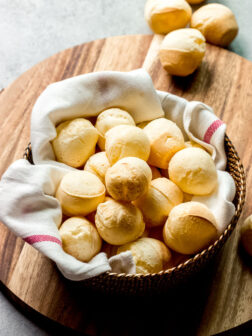 Gluten free cheese bread in basket on wooden board