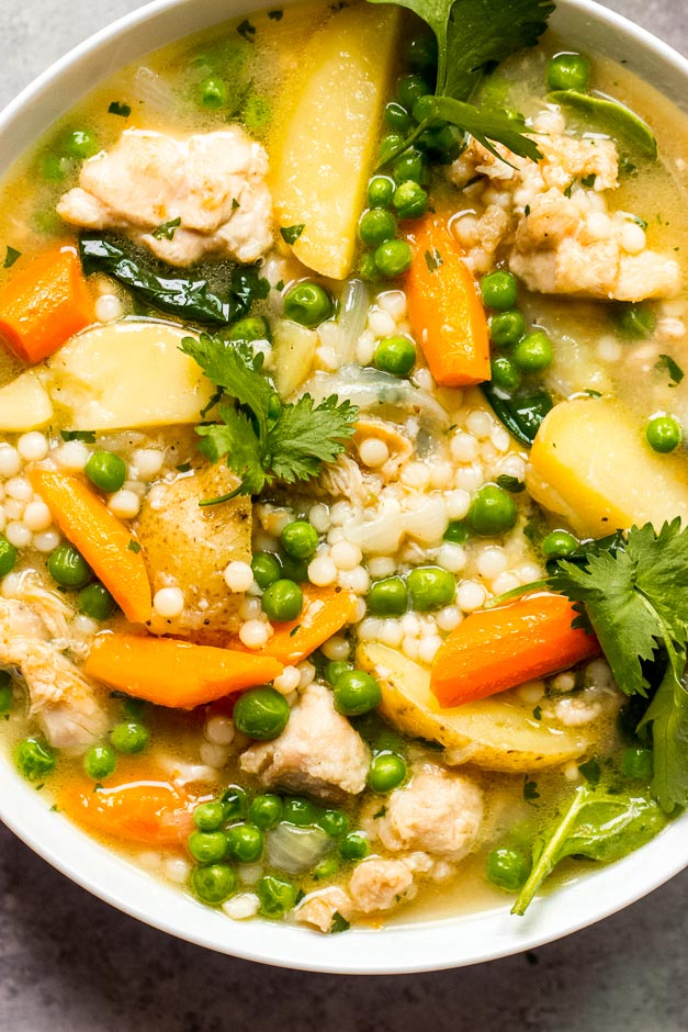 Overhead close up chicken and vegetable stew in white bowl