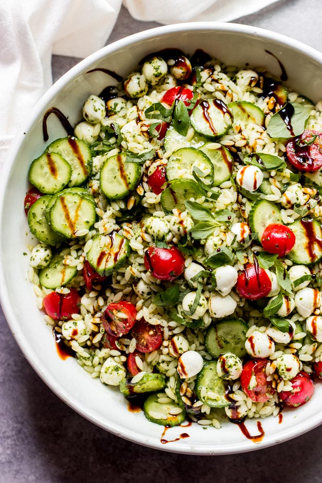 Overhead caprese orzo salad in white bowl