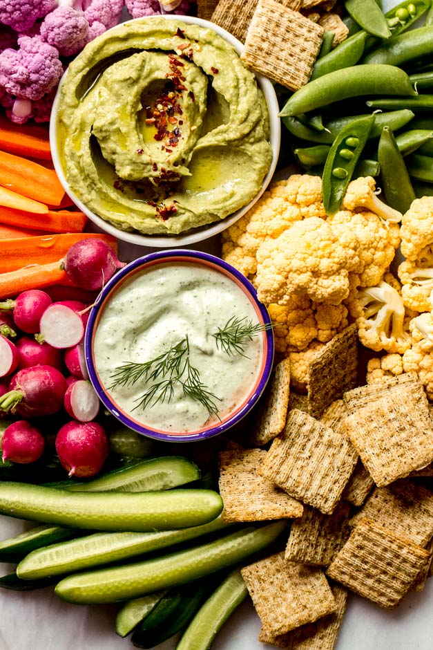 Close up vegetable platter with vegetable platters dips in the middle