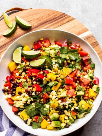 Overhead Mexican salad in white bowl on board