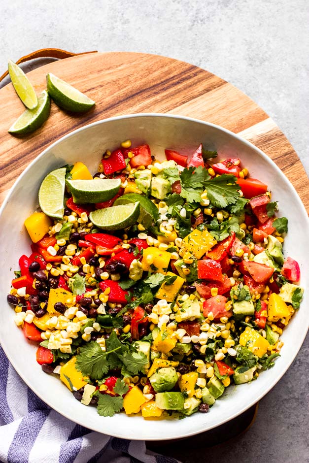 Overhead Mexican salad in white bowl on board.