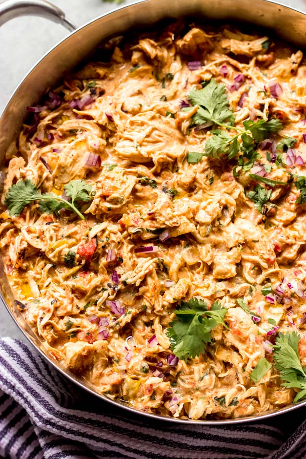 Close up stove top creamy shredded chicken in a dutch oven