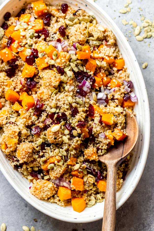 quinoa squash salad in a bowl with wooden spoon.