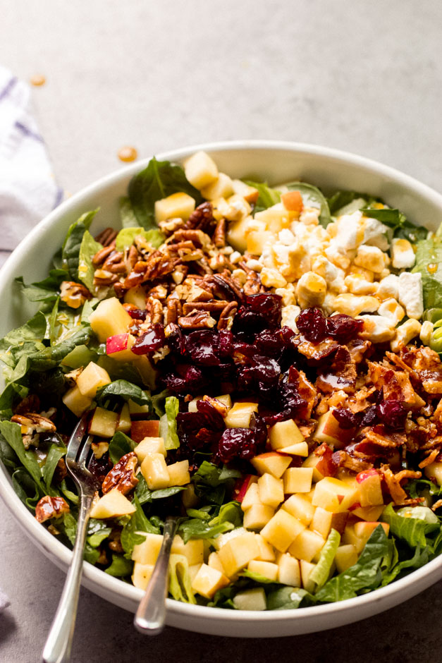 spinach and apple salad in white bowl