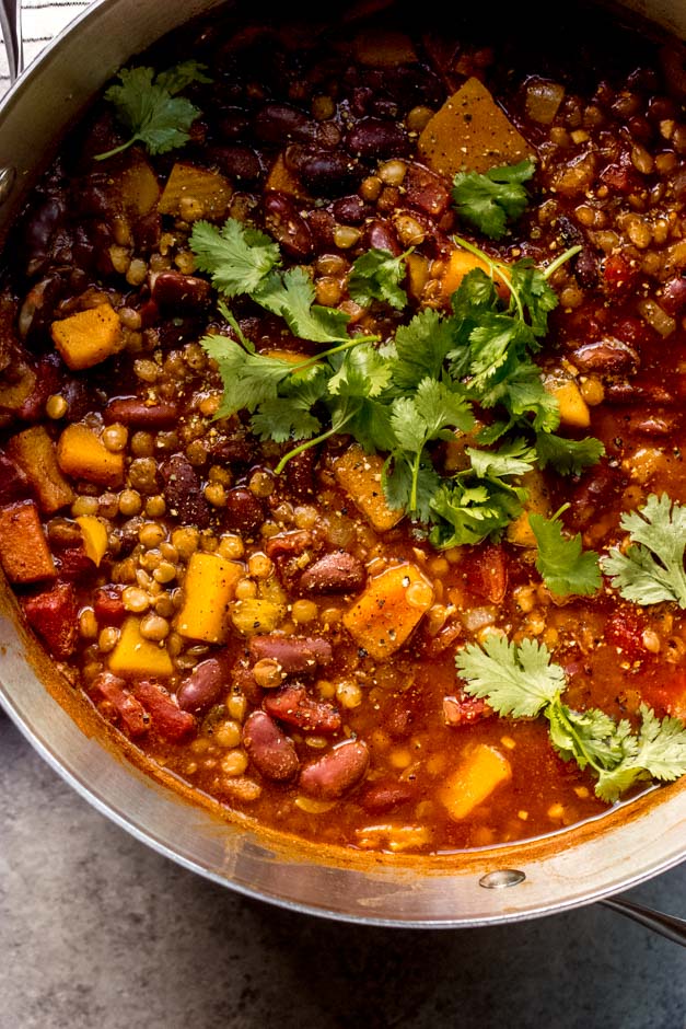 close up butternut squash and lentils chili in soup pot