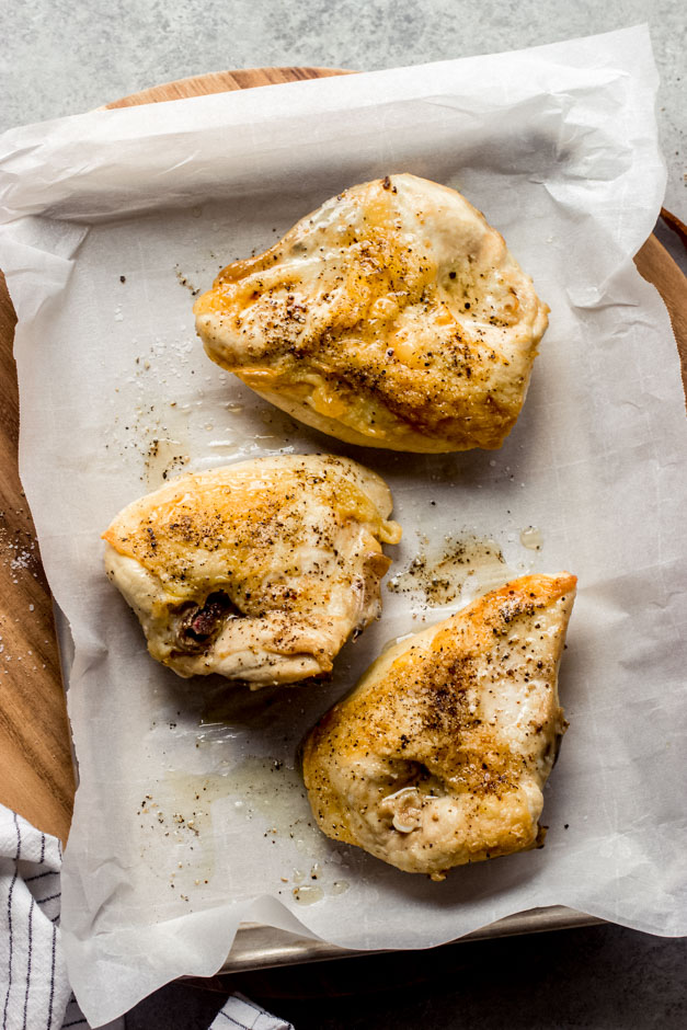 roasted bone-in chicken breast on a baking sheet.