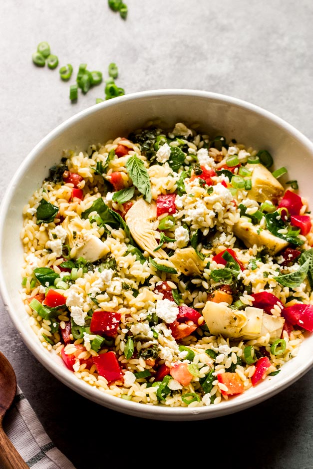 close up orzo spinach salad with artichokes