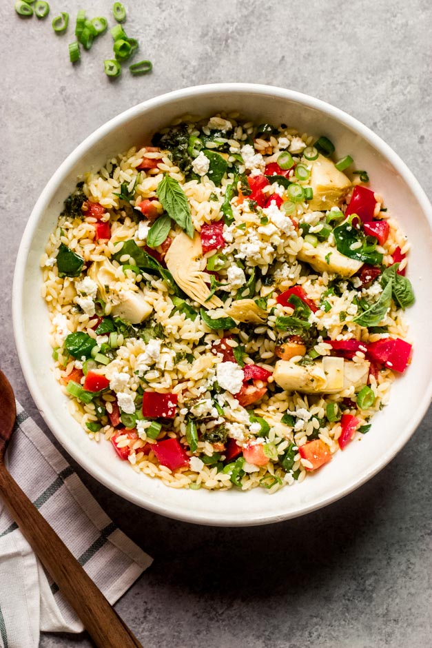 spinach orzo salad in white bowl