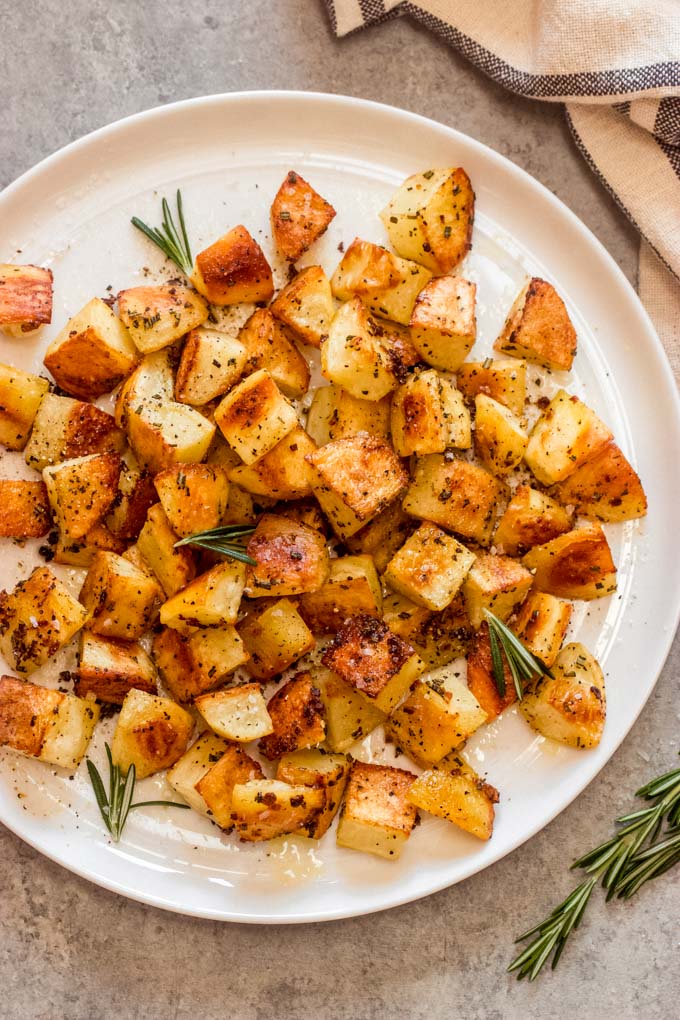 rosemary garlic potatoes on a white plate.