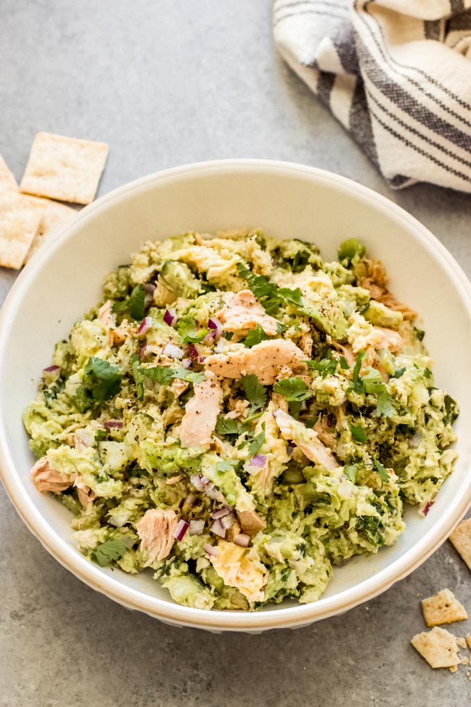 tuna and avocado salad in a bowl with crackers.